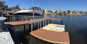 An aluminum direct drive boat lift next to a stationary dock and floating docks