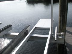 An aluminum stern platform lift accessory installed on a boat lift